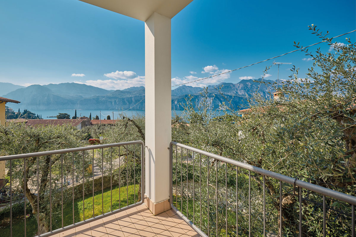 appartamento-casa-tea-lago-di-garda Angolo tranquillo del terrazzo dell'appartamento vacanze “Casa Tea” di Casa Ré da cui si gode una vista sul giardino mediterraneo, sugli ulivi e uno scorcio del Lago di Garda.